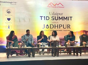 A panel discussion with five people sitting in a row on the stage.